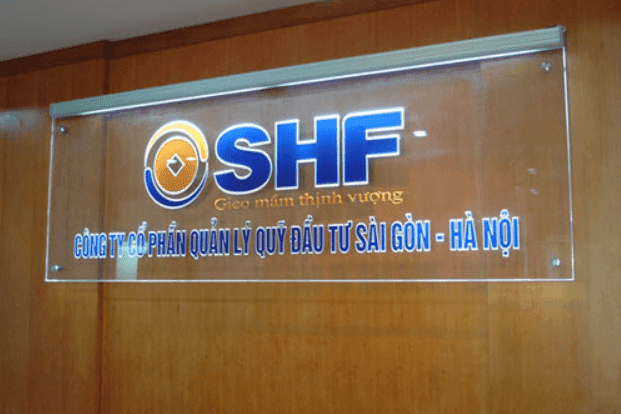 Hình ảnh một bảng hiệu mica cỡ vừa được gắn trước cửa một cửa hàng nhỏ hoặc văn phòng khởi nghiệp, với logo và tên thương hiệu được in hoặc khắc rõ ràng, sắc nét.